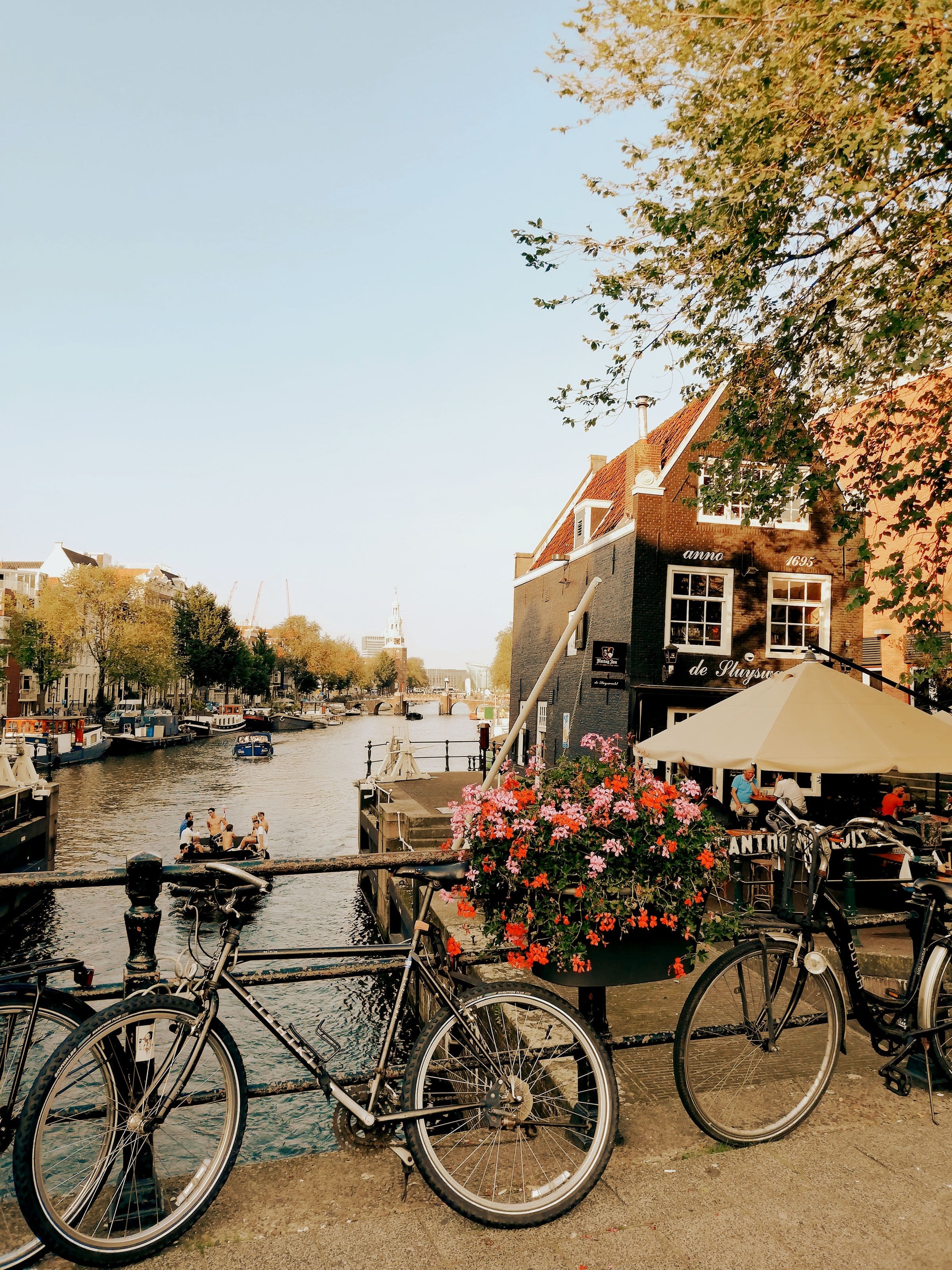 Bikes and a canal-side cafe in Amsterdam at golden hour