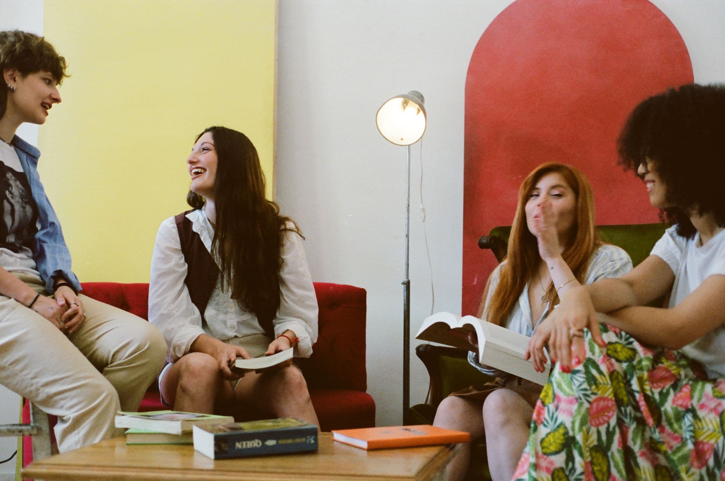 A book club laughing together on the sofa