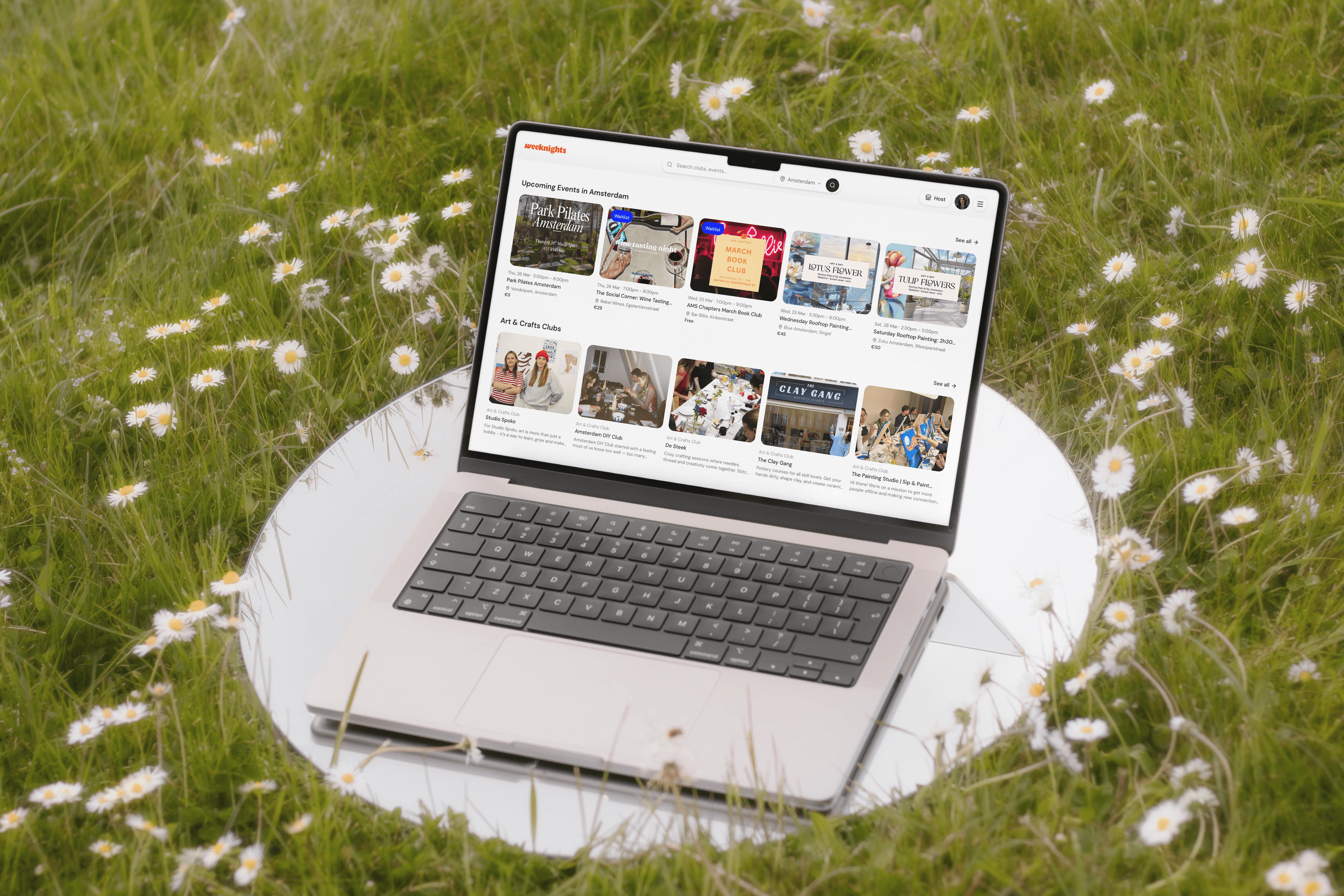 Weeknights platform shown on a laptop in a field of daisies