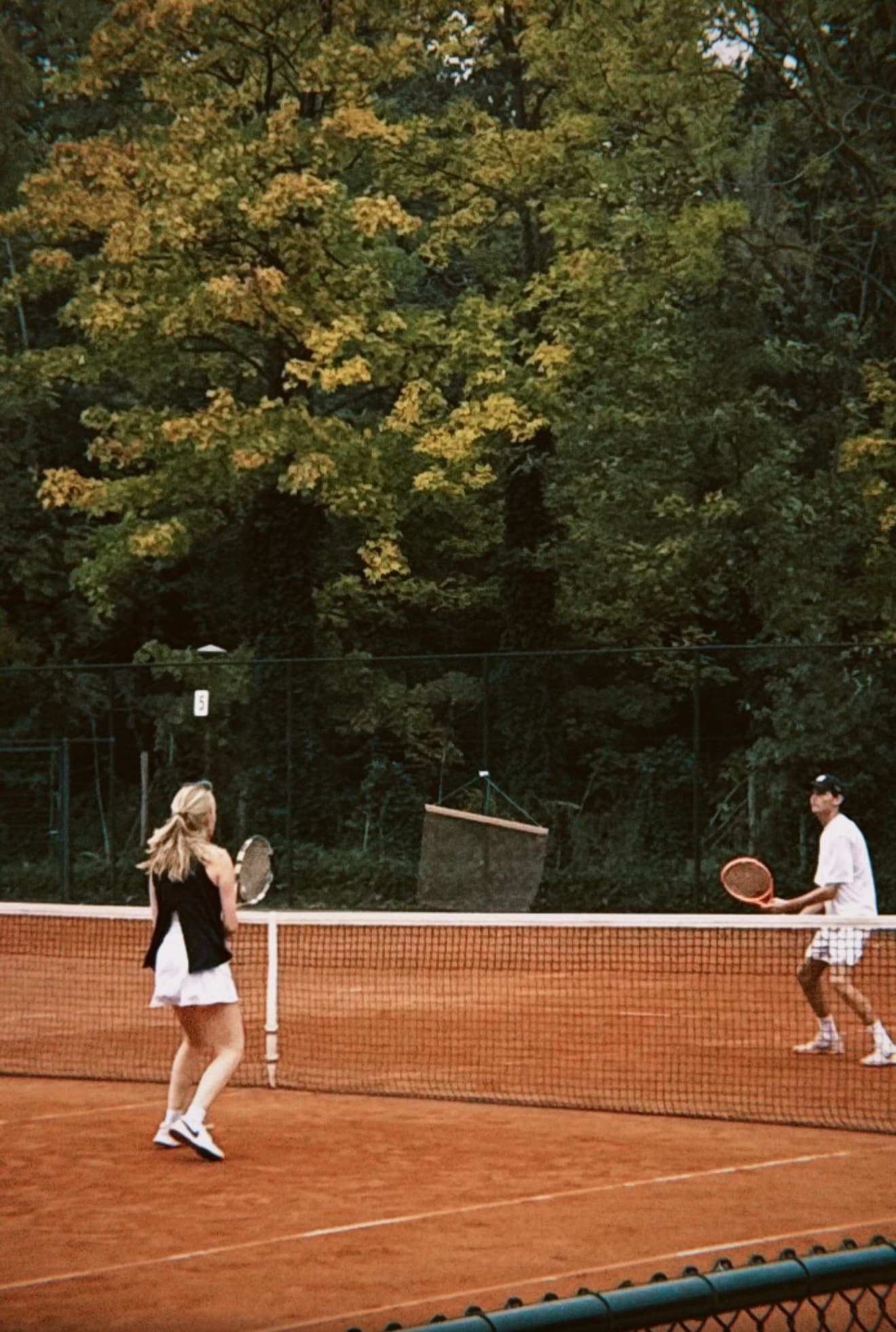 Two players at the net during a tennis club match