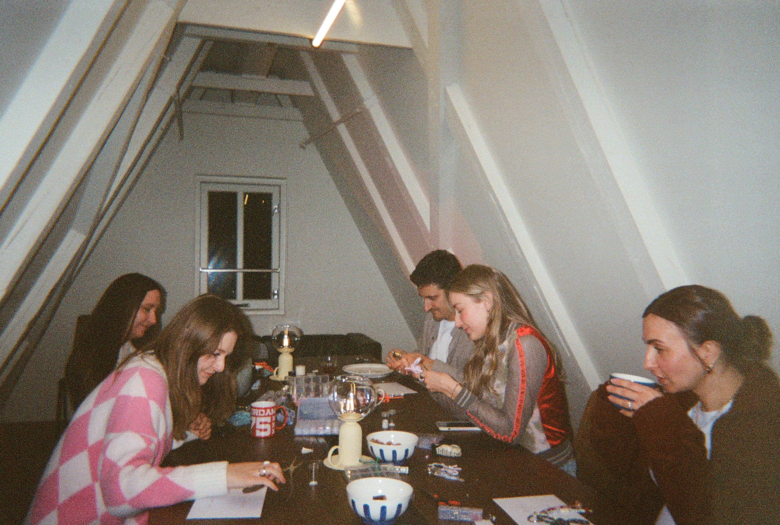 Hosts and guests gathered around a table at a supper club